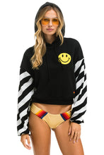 Last inn bildet i Galleri-visningsprogrammet, CAUTION STRIPE SLEEVE SMILEY 2 EMBROIDERY RELAXED CROPPED PULLOVER HOODIE - BLACK // WHITE Hoodie Aviator Nation